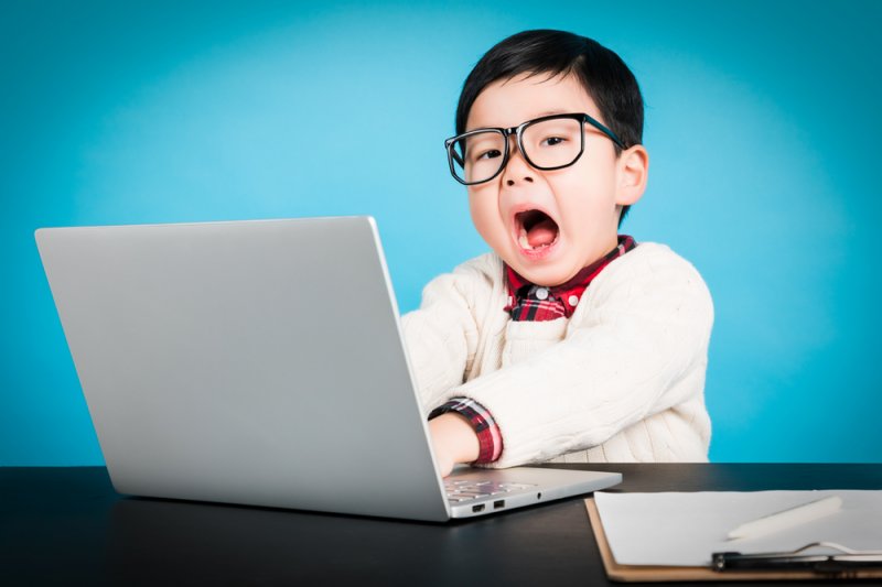 Young child in front of laptop looking surprised