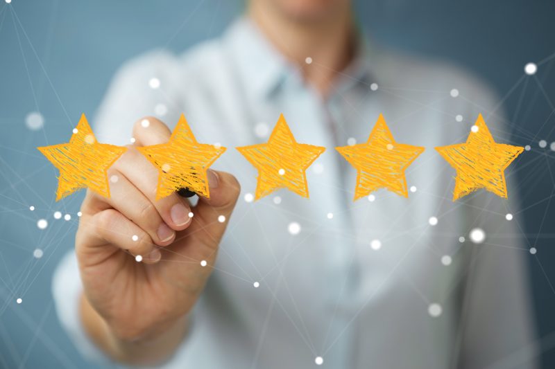 Review Savvy, image shows five gold stars with a woman in the background
