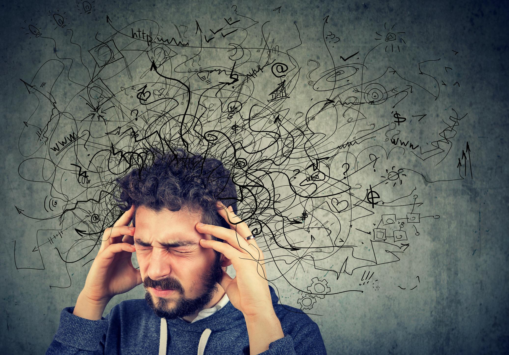 Image shows a man with his hands on his head, illustrated squiggles and lines hovering around his head. He looks frustrated. The image accompanies an article on How to Avoid Brain Strain in Legal Writing