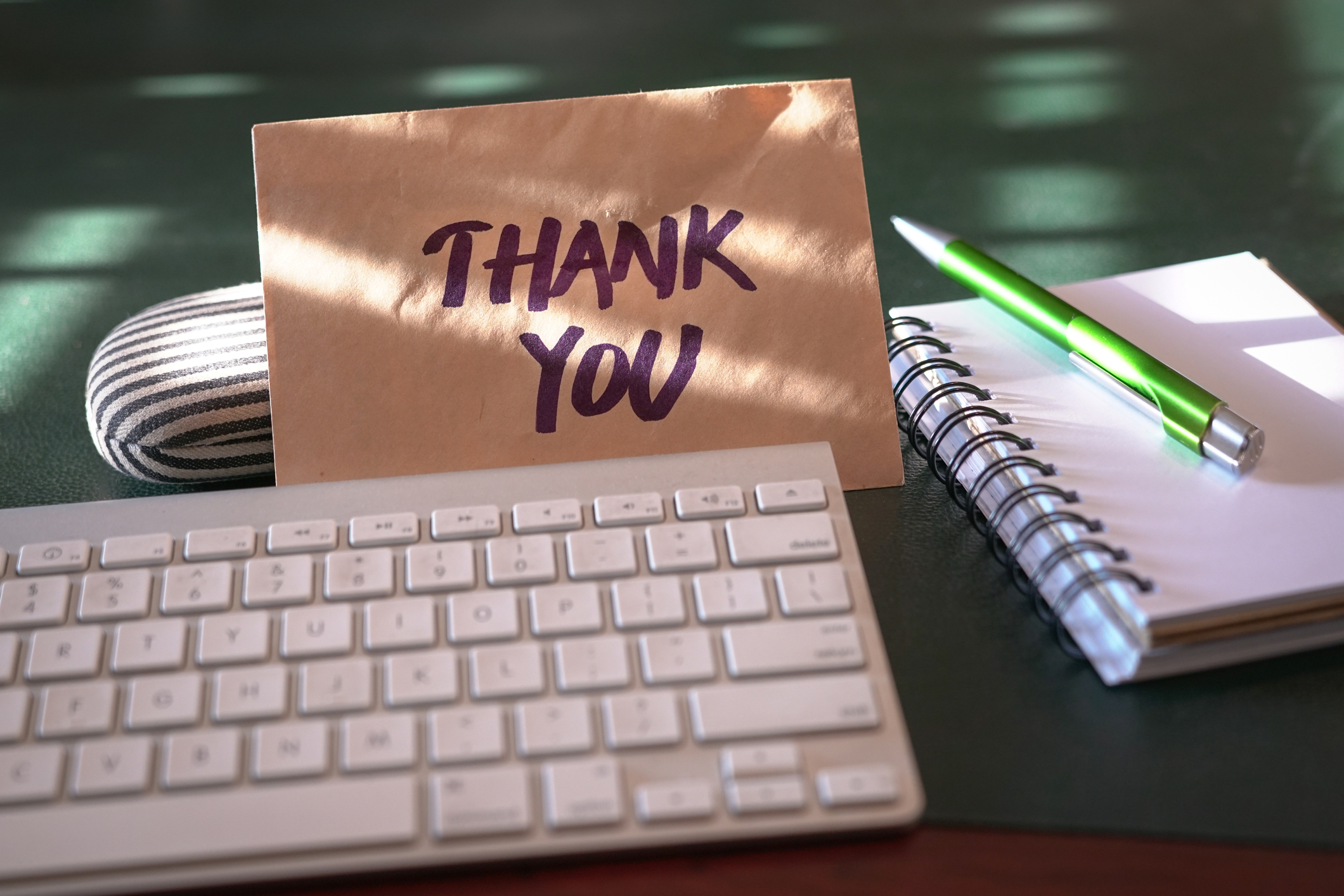 Image shows an envelop that says "thank you" sitting next to a keyboard. It accompanies a story on National Paralegal Day.
